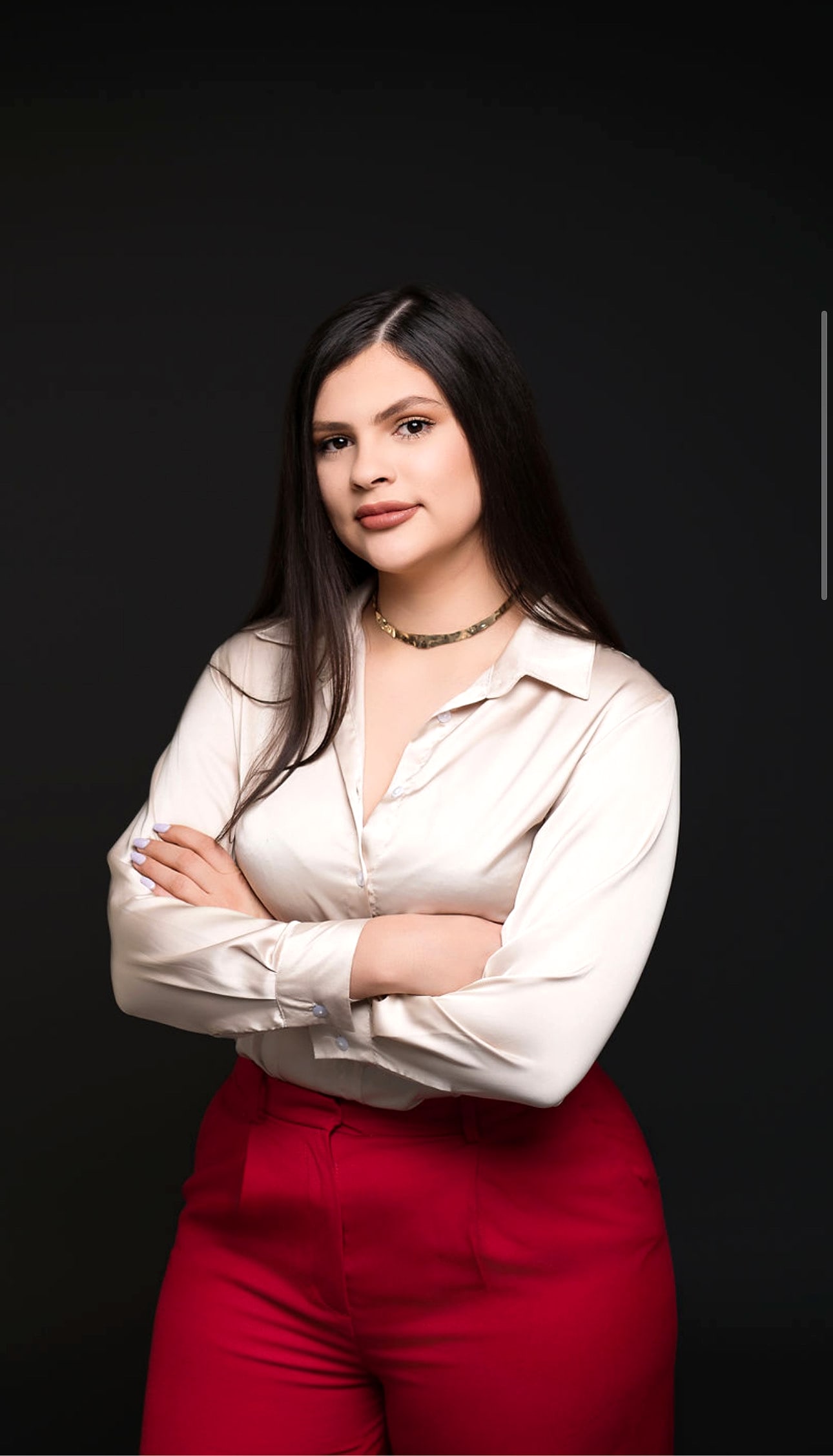 Portrait of Margo Ruiz, bilingual luxury Realtor, arms crossed in a cream satin blouse